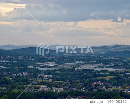 Panoramic view of a small town in a green valley under cloudy sky Panoramic view of a small town in a green valley under cloudy sky 140450323