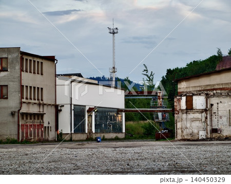 Abandoned industrial buildings with tall communication mast 140450329