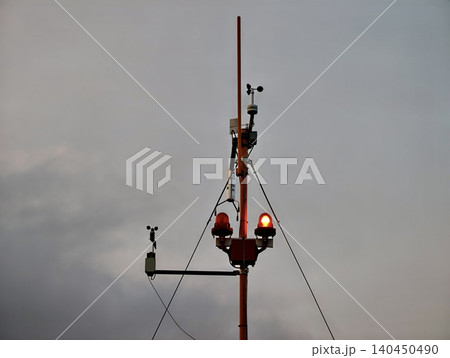 Weather monitoring mast with sensors against overcast sky Weather monitoring mast with sensors against overcast sky 140450490