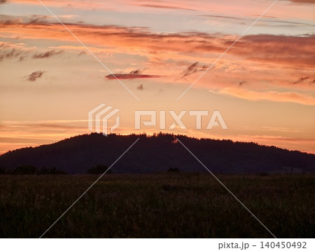 Sunset sky over dark hillside landscape Sunset sky over dark hillside landscape 140450492