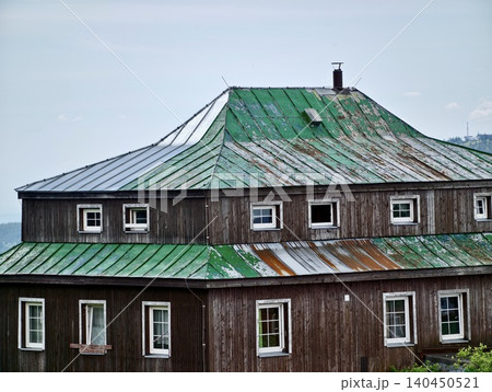Weathered wooden house with green metal roof Weathered wooden house with green metal roof 140450521