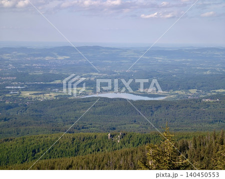 Panoramic mountain landscape with forested hills and distant lake 140450553