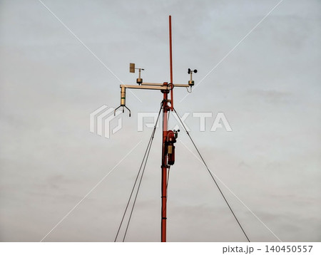 Weather monitoring mast with instruments against cloudy sky Weather monitoring mast with instruments against cloudy sky 140450557