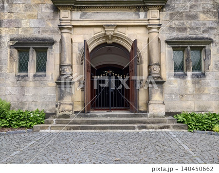 Stone entrance with open wooden doors and iron gate Stone entrance with open wooden doors and iron gate 140450662