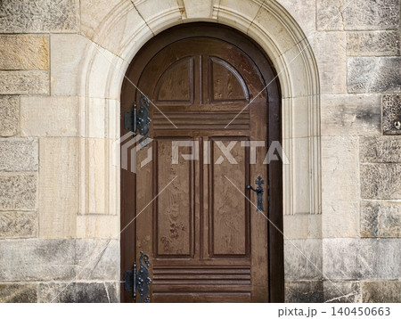 Arched wooden door set in stone building entrance Arched wooden door set in stone building entrance 140450663