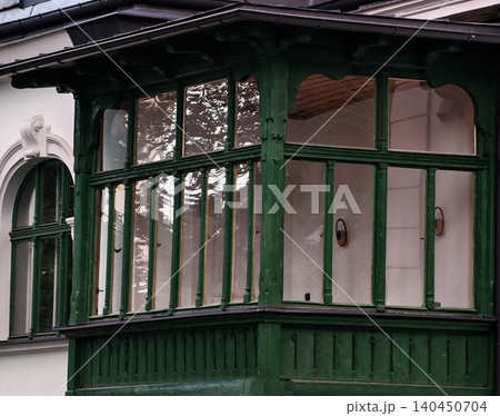 Historic building enclosed green wooden porch with large glass windows Historic building enclosed green wooden porch with large glass windows 140450704