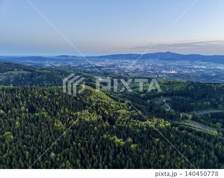 Peaceful Hilltop And City View. Morning Aerial View Of Peaceful Pine Hills And Distant Urban Skyline Peaceful Hilltop And City View. Morning Aerial View Of Peaceful Pine Hills And Distant Urban Skyline 140450778