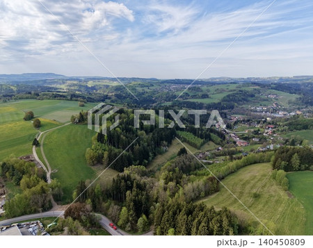 Idyllic Rural Roadway Stretching Towards Quaint Settlement Amid Rolling Hills And Expansive Skies Idyllic Rural Roadway Stretching Towards Quaint Settlement Amid Rolling Hills And Expansive Skies 140450809