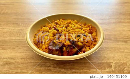 A delicious spicy rice dish with flavorful meat and fresh vegetables, ideal for gatherings 140451109
