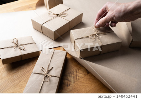 Woman adjusting bow wrapped Christmas gift box Woman adjusting bow wrapped Christmas gift box 140452441