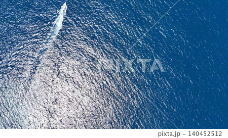 青いキャンバスのような海面を進む小舟│太陽の光にきらめく美しい海と船の空撮 青いキャンバスのような海面を進む小舟│太陽の光にきらめく美しい海と船の空撮 140452512
