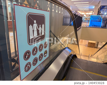 Escalator safety instructions with symbols and guidelines in public space 140453028