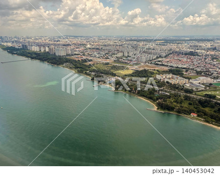 Aerial view of the coastline and urban landscape of Singapore with clouds in the sky 140453042