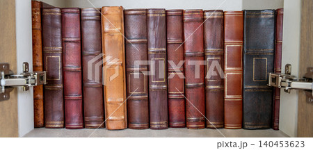 Antique leather bound books collection in cabinet. Set of ancient law book on bookshelf in library Antique leather bound books collection in cabinet. Set of ancient law book on bookshelf in library 140453623