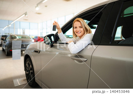 Happy woman buying new car holding keys Happy woman buying new car holding keys 140453846