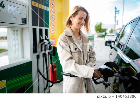 Woman refueling car with diesel at gas station Woman refueling car with diesel at gas station 140453886