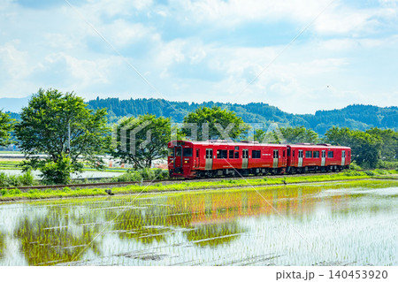 田植えの水田の横を駆けぬけるローカル線 田植えの水田の横を駆けぬけるローカル線 140453920