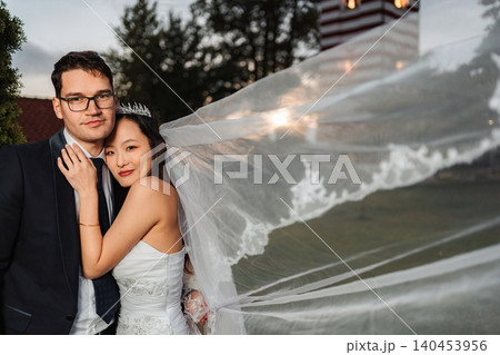 Bride and groom celebrating interracial wedding outdoor portrait Bride and groom celebrating interracial wedding outdoor portrait 140453956