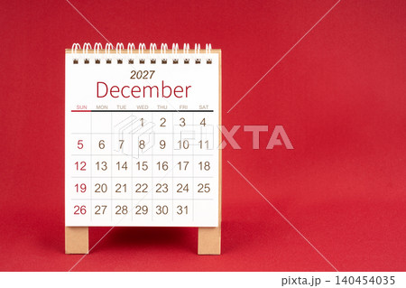 Blank desk calendar for December 2027 on red background. 140454035
