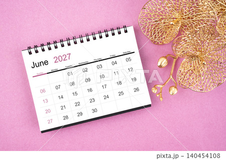 June 2027 desk calendar with golden orchid on pink color background. 140454108