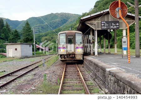 芸備線のローカル列車キハ120形と新緑の備後落合駅のホーム 140454993