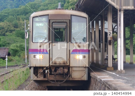 芸備線のローカル列車キハ120形と新緑の備後落合駅のホーム 140454994