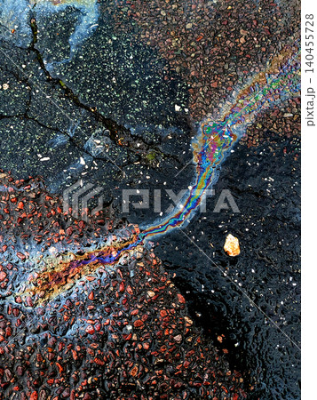 A leaked Car Oil Petrol in The Rain on a Tarmac Road Metallic Rainbow A leaked Car Oil Petrol in The Rain on a Tarmac Road Metallic Rainbow 140455728