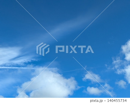 Beautiful blue summer air with fluffy white clouds and chem trail lines across the sky Beautiful blue summer air with fluffy white clouds and chem trail lines across the sky 140455734