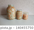 Homemade fermented cabbage and shredded carrots with spices in clear glass jars, preparing traditional eastern european sauerkraut for healthy probiotic food storage 140455750