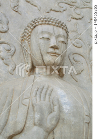Stone Buddha statue with raised hand 140455865