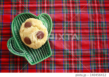 Chocolate cookies on small green plate cactus. Red background 140456412
