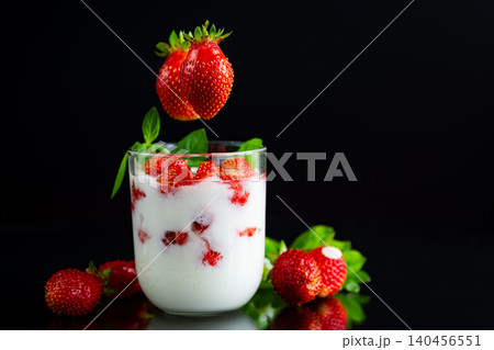 Summer berry dessert in glass with dark background lighting Summer berry dessert in glass with dark background lighting 140456551