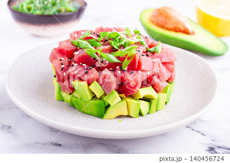 Fresh tuna tartare with avocado served on a marble table with soy sauce and seaweed salad Fresh tuna tartare with avocado served on a marble table with soy sauce and seaweed salad 140456724