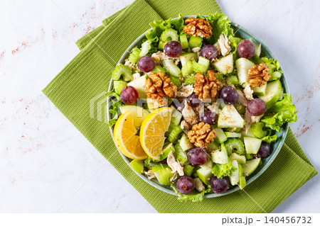 Fresh Waldorf salad, celery stalk with chicken, apple and walnuts, grapes, herbs, homemade, without people, 140456732