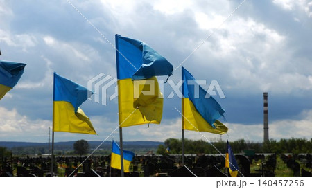 View on blue-yellow flags at countless graves of ukrainian soldiers alley of glory in Kharkiv. This site commemorates heroes and maintains the memory of wartime events in Ukraine. Slow moiton View on blue-yellow flags at countless graves of ukrainian soldiers alley of glory in Kharkiv. This site commemorates heroes and maintains the memory of wartime events in Ukraine. Slow moiton 140457256