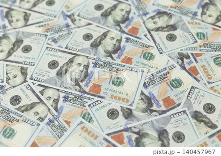 Hundreds of dollar bills scattered across a surface. Images convey abundance or financial gain. Ideal for business, finance, or economic themes.  140457967