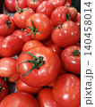 Fresh red tomatoes still on the vine offering a vibrant display of healthy produce, showcasing ripeness and the abundance of a garden harvest 140458014