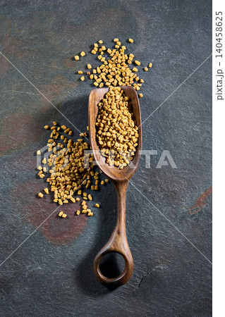 Fenugreek seeds on graphite background Fenugreek seeds on graphite background 140458625