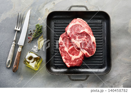 Beefsteak with spices and grill skillet on stone background Beefsteak with spices and grill skillet on stone background 140458782