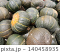 Kabocha squash pile at a grocery store, showing fresh green and yellow-striped gourds ready for sale, representing healthy eating, autumn harvest, and seasonal produce 140458935