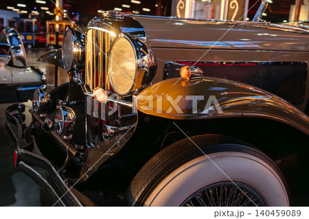 Luxury vintage convertible car with chrome grille and whitewall tires displayed in a retro automobile museum. Elegant historic vehicle with classic design and polished metal details under warm Luxury vintage convertible car with chrome grille and whitewall tires displayed in a retro automobile museum. Elegant historic vehicle with classic design and polished metal details under warm 140459089