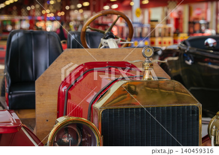 Vintage car front view showcasing hood, grille, headlights in museum setting Vintage car front view showcasing hood, grille, headlights in museum setting 140459316