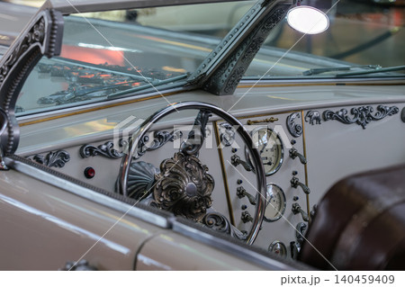 Vintage car dashboard with ornate trim and gauges in showroom 140459409