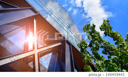 Eco building in modern city concept. Modern office building with the fresh green leaves. Steel and glass. The subject of modern architecture or construction industry.  140459441