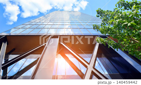 Eco building in modern city concept. Modern office building with the fresh green leaves. Steel and glass. The subject of modern architecture or construction industry.  140459442