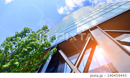 Eco building in modern city concept. Modern office building with the fresh green leaves. Steel and glass. The subject of modern architecture or construction industry. Eco building in modern city concept. Modern office building with the fresh green leaves. Steel and glass. The subject of modern architecture or construction industry. 140459443