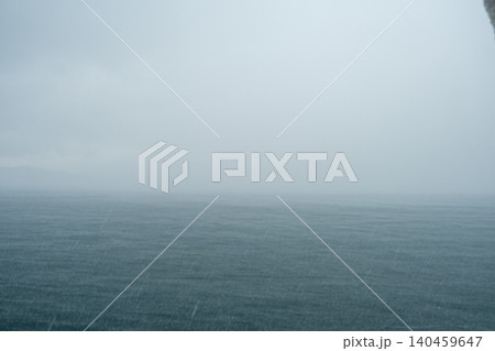 Heavy rain falls over the Bosphorus Strait as waves surge, creating a moody atmosphere and obscuring the horizon in a stormy afternoon setting. 140459647