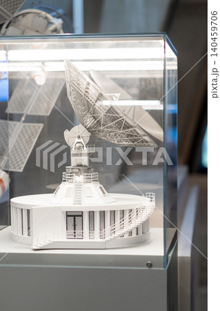 Detailed model of a satellite dish positioned in a glass case, highlighting intricate design elements at a science museum. 140459706
