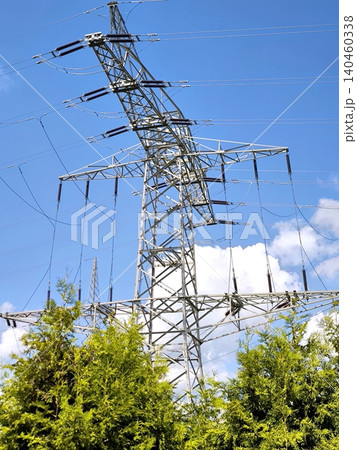 Power transmission tower against a blue sky with clouds 140460338
