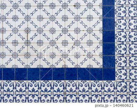 Classic Portuguese azulejos wall with a geometric arrangement of intricate white and blue floral patterned ceramic tiles separated by a deep blue border Classic Portuguese azulejos wall with a geometric arrangement of intricate white and blue floral patterned ceramic tiles separated by a deep blue border 140460621